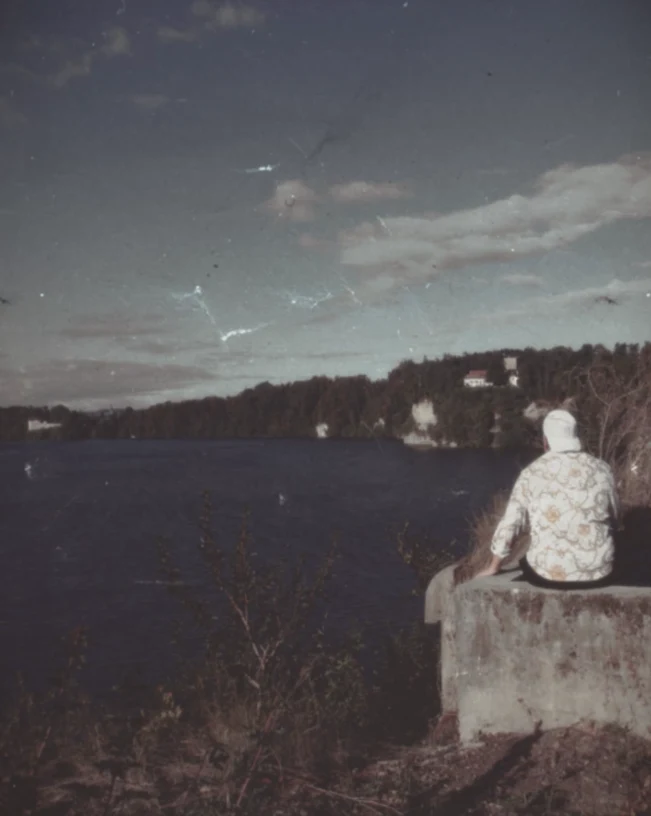 Rückenansicht am Seeufer, Blick über das Wasser — Aufnahme im Vintage-Filmlook